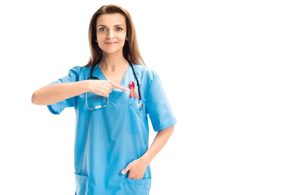 Médico atraente apontando em fita vermelha isolada em branco, conceito de dia ajudas mundo — Fotografia de Stock