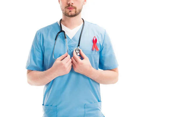 Cropped image of doctor with red ribbon touching stethoscope isolated on white, world aids day concept — Stock Photo