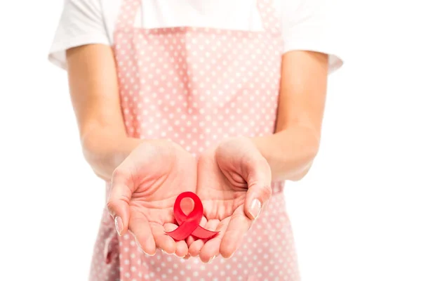 Cropped image of housewife in pink apron holding red ribbon isolated on white, world aids day concept — Stock Photo