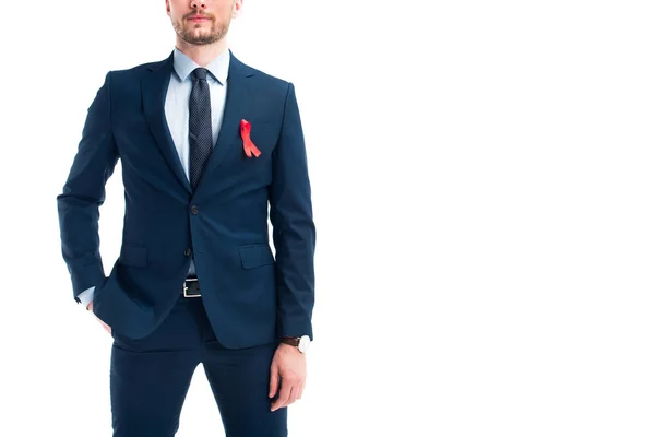 Image recadrée d'homme d'affaires debout avec ruban rouge sur costume isolé sur blanc, concept de journée mondiale des aides — Photo de stock