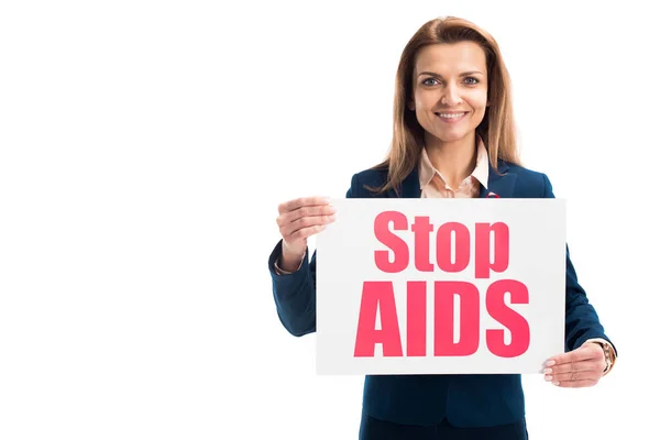 Sorridente donna d'affari attraente che mostra carta con stop aids testo isolato su bianco — Foto stock