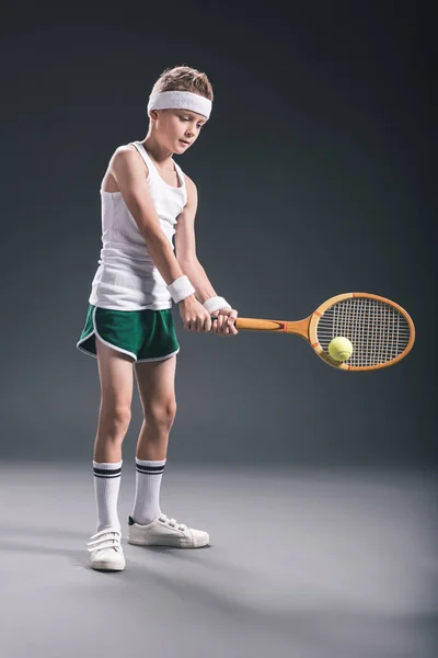 Preteen menino em sportswear com raquete de tênis e bola no fundo escuro — Fotografia de Stock