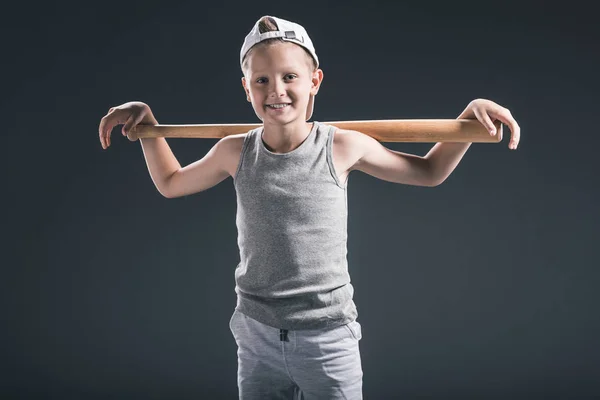 Portrait of preteen boy in cap with baseball bat on grey background — Stock Photo