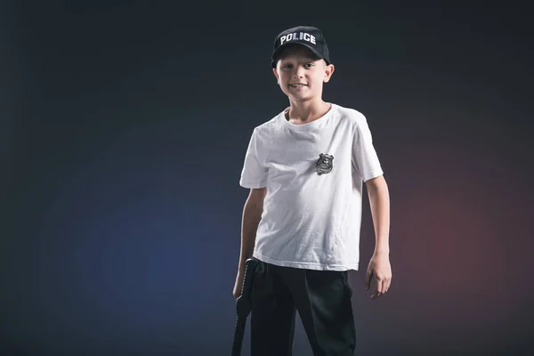 Portrait of preteen boy in white tshirt and cap police officer uniform in dark backdrop — Stock Photo
