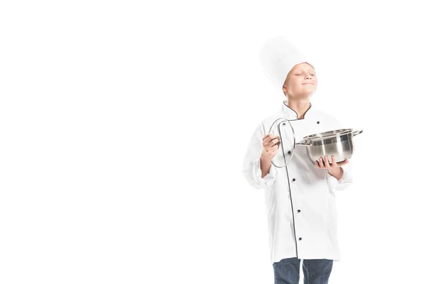 Portrait de garçon pré-adolescent en uniforme de chef avec casserole isolée sur blanc — Photo de stock