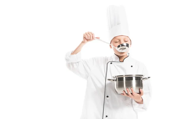 Pre-adolescent boy in chef uniform with saucepan and ladle isolated on white — Stock Photo