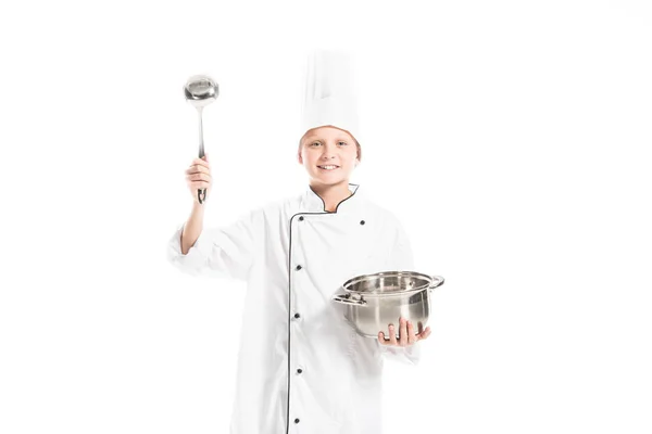 Pre-adolescent boy in chef uniform with saucepan and ladle isolated on white — Stock Photo
