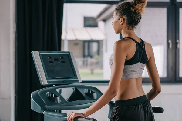 Rear view of african american female athlete on treadmill at gym — Stock Photo