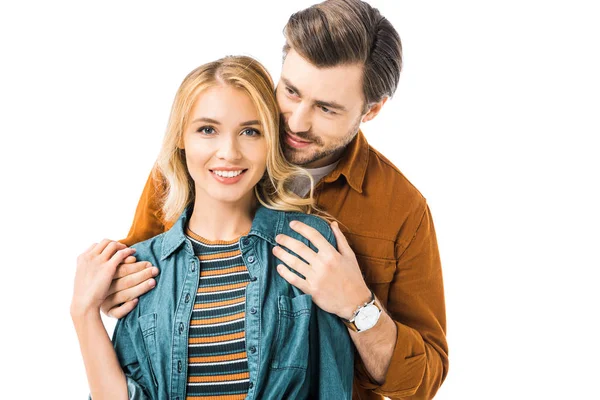 Joven hombre abrazando novia por detrás aislado en blanco - foto de stock