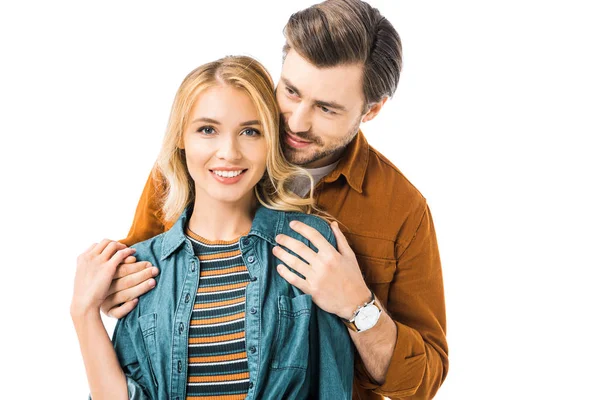 Young man embracing girlfriend from behind isolated on white — Stock Photo