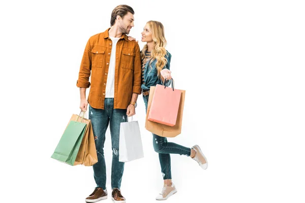 Пара тримає барвисті сумки для покупок і дивиться один на одного ізольовано на білому — стокове фото