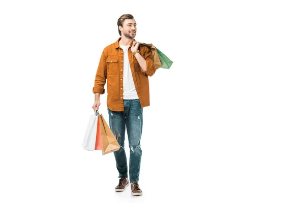 Hombre feliz caminando con coloridas bolsas de compras aisladas en blanco - foto de stock