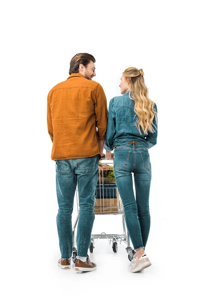 Vue arrière du couple transportant un chariot avec des produits isolés sur blanc — Photo de stock