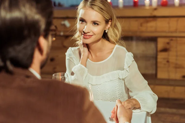 Селективное внимание красивой женщины, встречающейся с парнем в ресторане — стоковое фото