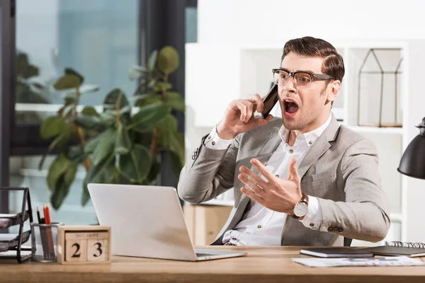 Homme d'affaires en colère parler par téléphone et crier sur le lieu de travail au bureau — Photo de stock