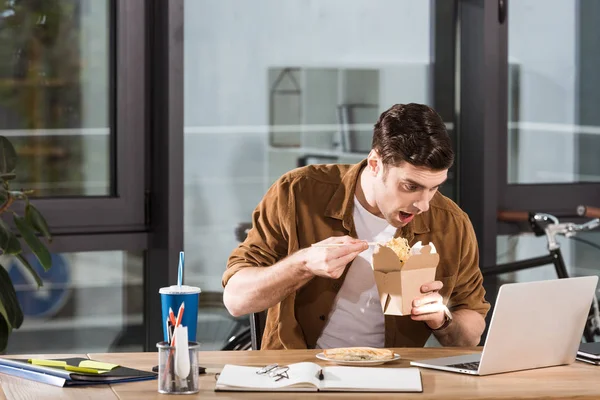 Empresário faminto comer levar macarrão de caixa no escritório — Fotografia de Stock