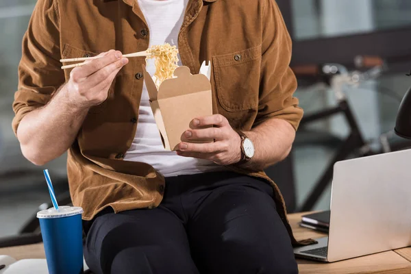 Tiro cortado de empresário comer levar macarrão de caixa no escritório — Fotografia de Stock