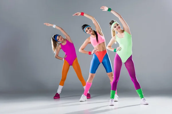 Attraktive sportliche Mädchen im Body-Training beim Aerobic-Workout auf grau — Stockfoto