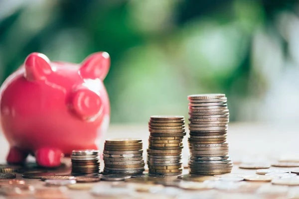 Stacked coins and pink piggy bank, close-up view — Stock Photo