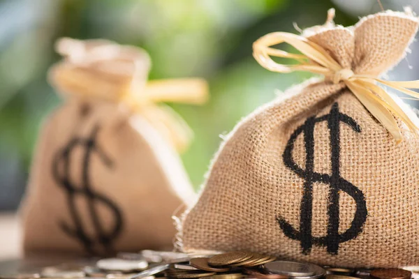 Close-up view of sackcloth bags with dollar sign and coins — Stock Photo