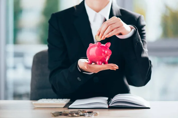 Tiro cortado de empresária colocando moeda em rosa porquinho banco — Fotografia de Stock