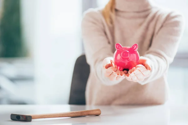 Cropped shot of woman holding pink piggy bank — Stock Photo