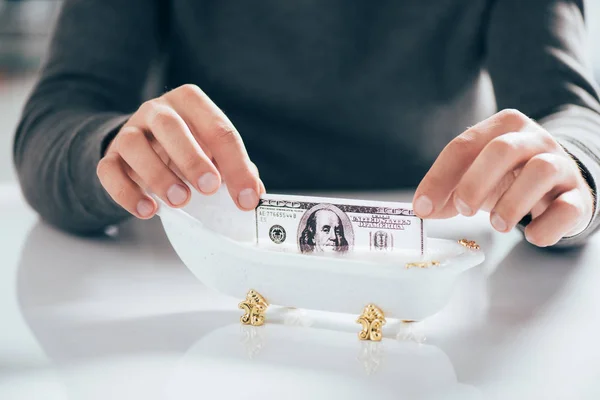 Обрезанный снимок человека, стирающего банкноты в ванной, концепция отмывания денег — стоковое фото