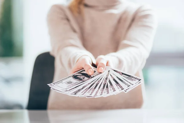 Крупним планом частковий вид жінки, що тримає доларові банкноти — стокове фото