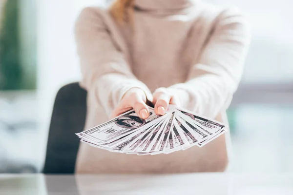 Nahaufnahme einer Frau, die Dollarscheine in der Hand hält — Stockfoto