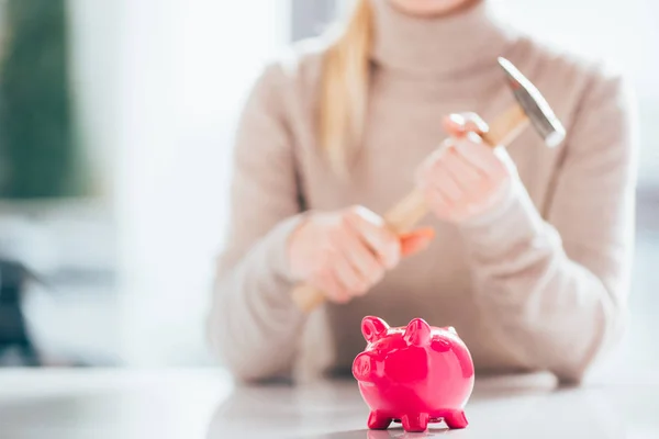 Close-up view of pink piggy bank and woman holding hammer behind — Stock Photo