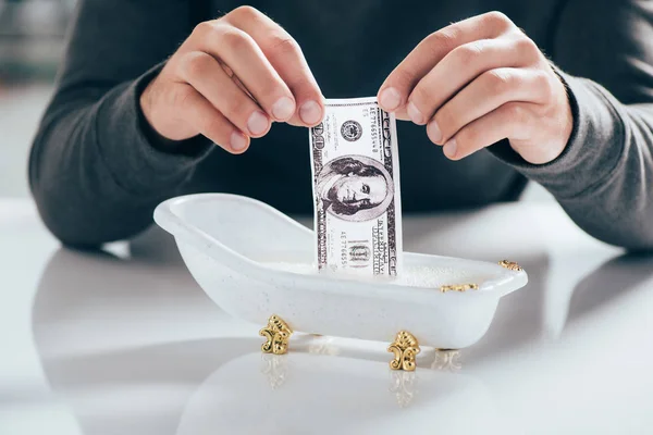 Tiro recortado de homem lavando nota de dólar em pequena banheira, conceito de lavagem de dinheiro — Fotografia de Stock
