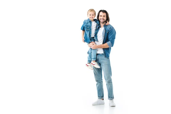 Padre sosteniendo a su hermoso hijo y mirando a la cámara aislada en blanco - foto de stock