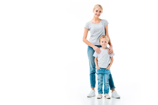 Красивая мать и ее маленький сын в джинсах и серых футболках, изолированных на белом — стоковое фото