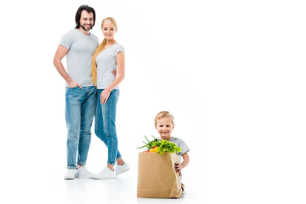 Kleiner Junge mit Einkaufstasche und seine Eltern stehen isoliert auf weiß — Stockfoto