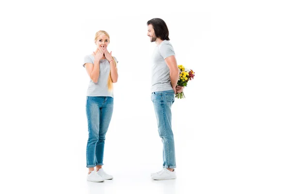 Choqué fille et l'homme cacher bouquet de fleurs isolé sur blanc — Photo de stock