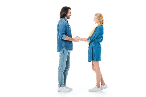 Homem e mulher de mãos dadas e olhando uns para os outros isolados em branco — Fotografia de Stock