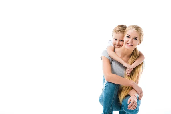 Pequeno filho feliz abraçando sua bela mãe isolada no branco — Fotografia de Stock