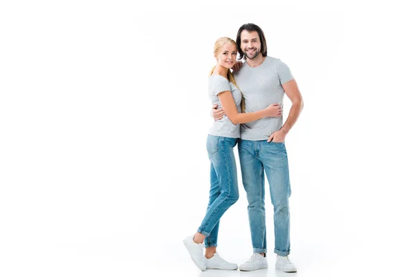 Lindo casal vestindo jeans e cinza camiseta abraçando uns aos outros isolado no branco — Fotografia de Stock