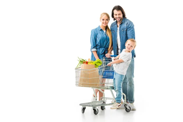 Familia feliz con carrito de la compra y bolsa de supermercado llena de alimentos saludables aislados en blanco - foto de stock