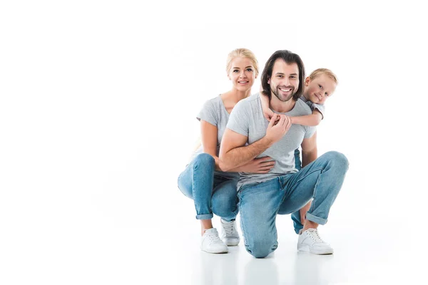 Familia sonriente abrazándose juntos aislados en blanco - foto de stock