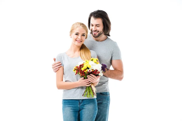 Meraviglioso coppia abbracci mentre donna holding fiori isolato su bianco — Foto stock