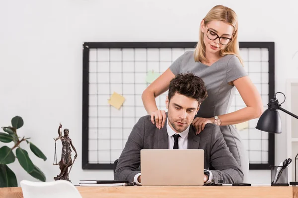 Бізнес-леді робить масаж колезі на робочому місці в офісі, концепція офісної романтики — стокове фото