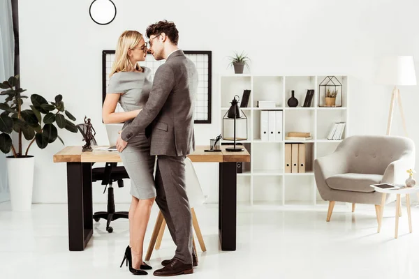 Jeunes avocats se serrant les uns les autres tout en restant au bureau, flirt et concept de romance de bureau — Photo de stock