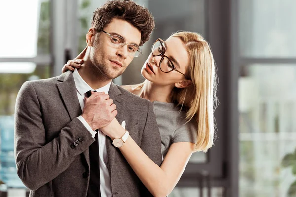 Porträt der schönen Geschäftsfrau umarmt stilvollen Geschäftsmann im Büro, Flirt und Büro-Romantik-Konzept — Stockfoto