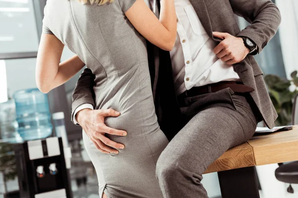 Tiro recortado de colegas de negócios abraçando e flertando no local de trabalho, conceito de romance de escritório — Fotografia de Stock