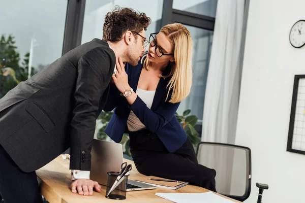 Attraktive junge Geschäftsfrau flirtet mit Geschäftskollegin am Arbeitsplatz im Büro — Stockfoto