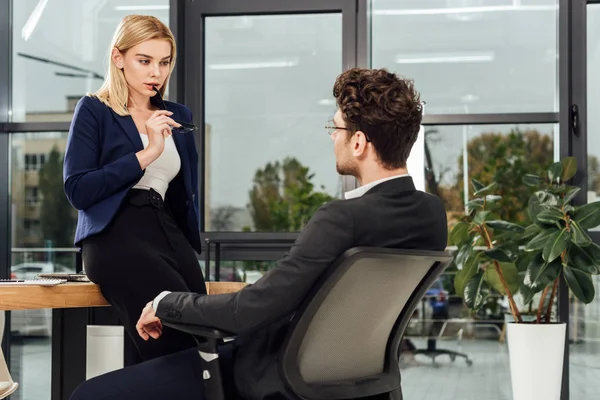 Attraktive Geschäftsfrau flirtet mit Geschäftskollegin am Arbeitsplatz im Büro — Stockfoto