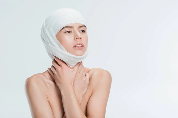 Femme nue avec des bandages sur la tête après une chirurgie plastique isolé sur blanc — Photo de stock