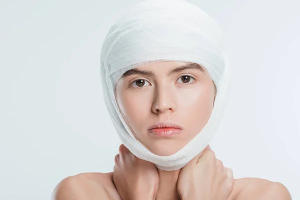 Close up of adult woman with bandages on head isolated on white — Stock Photo