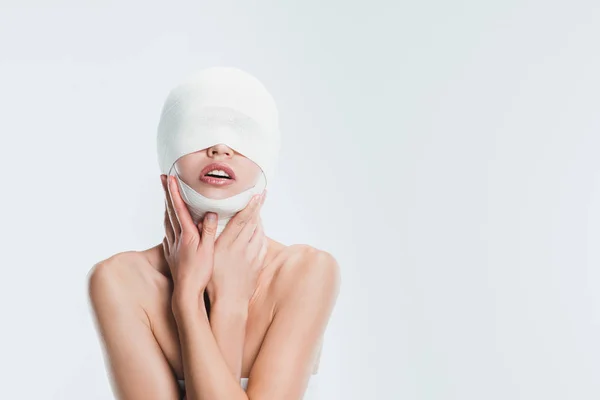 Femme nue avec des bandages sur la tête après la chirurgie plastique isolé sur blanc — Photo de stock